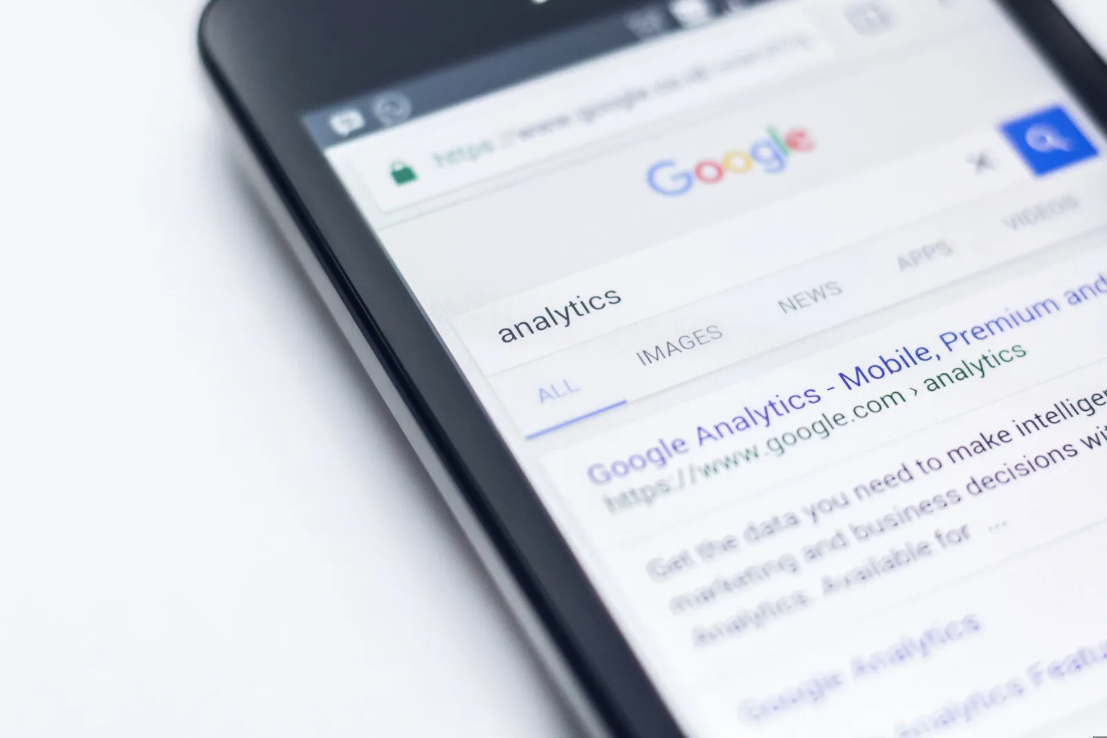 A phone displaying Google search results for the query analytics